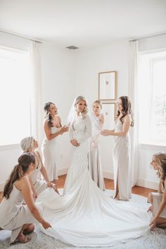 A bride getting ready with her bridesmaids. The bridesmaids are fixing the bottom of the wedding dress. Bridesmaids Helping Bride Get Dressed, Wedding Photoshoot With Bridesmaid, Bridesmaid Helping Bride, Bride Reveal To Bridesmaids, Bridesmaids Poses With Bride, Bridesmaid Picture Ideas Getting Ready, Bride Getting Ready With Bridesmaids, Wedding Inspiration Photography, Cute Bridesmaid Photos