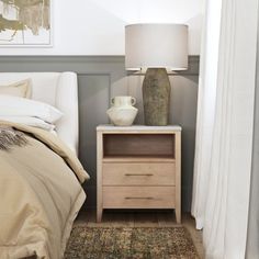 a bedroom with a bed, nightstand and painting on the wall