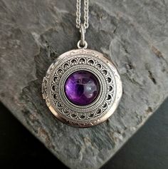 A beautiful purple amethyst centered on an intricate, antiqued silver filigree and set on an antiqued silver locket. Locket hangs from an antiqued silver chain. Locket opens with 2 spaces for pictures or things as shown.  Details: Locket measures 32mm in diameter Locket has a smooth back as shown  Locket and chain are plated brass Necklace measures 24 inches  Stones are genuine amethyst  Want a shorter chain? Just leave a note to seller at checkout for me and I can adjust it for you, no extra charge.  Please allow for possible slight color differences due to different settings on different screens.  Thank you for shopping Delicate Industry :) Necklace Gift Ideas, Art Deco Locket, Chain Locket, Crystal Locket, Silver Locket, Gift Ideas For Her, Silver Lockets, Amethyst Jewelry, Brass Necklace