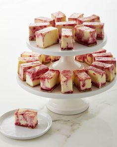 several pieces of cheesecake on a white cake stand