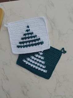 two crocheted dishcloths sitting on top of a counter