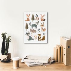 a wooden table topped with books and plants next to a wall mounted art print on the wall