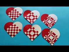 six heart shaped paper cut outs with checkered design on the front and back, set against a blue background