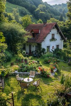 a small house in the middle of a lush green field with chairs and tables around it