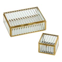 two clear glass boxes with gold trimmings on the sides and one is empty