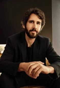 a man with long hair and beard sitting on a chair