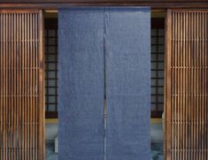 two wooden doors with blue curtains in front of them