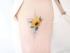 a woman with a sunflower tattoo on her left arm and behind her is a triangle