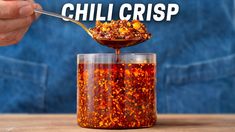 a person spooning chili into a glass jar with the words chill crisp on it