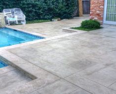 an empty pool in the middle of a backyard with steps leading up to it and a patio