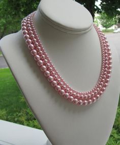 Graduated Pearl Necklace Set ~ This elegant pink pearl necklace set is made with 3 sizes of medium blush pink pearls. A very simple piece to add accent to your wardrobe without overpowering it; whether you are a bride walking down the aisle, or a woman getting ready for a day at the office.  The pink pearls mimic Sarah Jessica Parker's piece, as shown in the last picture and has a classic Jackie O vibe to it.  Earrings shown are included and measure approximately 1".This graduated pink pearl nec Pink Round Beads Jewelry For Bridesmaid Gift, Feminine Pink Pearl Necklace, Feminine Pink Pearl Necklace For Wedding, Woman Getting Ready, Pink Necklace Set, Pearl Necklace Pink, Bride Walking Down The Aisle, Graduated Pearl Necklace, Hand Beaded Bag