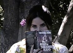 a woman holding up a book in front of her face