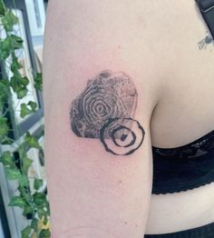 a woman's arm with a tattoo on it that looks like a spiral design