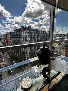 a glass table with a plate on it in front of a window overlooking a city