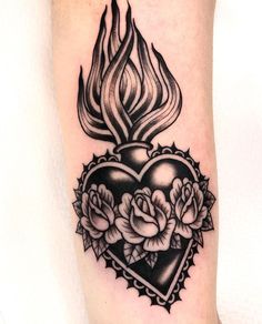 a heart tattoo with roses on the inside of it and a flame in the middle