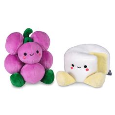 two small stuffed animals sitting next to each other on a white surface, one has a toothbrush and the other has a pink flower