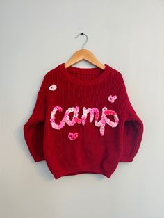 Valentines Custom Knit Sweater! The cutest hand embroidered sweater with a pink multicolor chunky yarn on an red sweater.  Sweaters are an oversized fit. Model is wearing 18-24 months sweater (but typically wears 18 month clothing). Stay true to size for baggy fit that will last even longer!  CARE: wash normal (recommended inside out but not necessary) and lay flat to dry to avoid yarn fuzzing.  For more info, questions, changes or customs- message us on here or on instagram @ campcoveco! Trendy Embroidered Knit Sweater, Cozy Red Cotton Sweater, Cute Long Sleeve Chunky Knit Sweater, Cute Chunky Knit Long Sleeve Sweater, Cozy Red Acrylic Sweater, Cute Chunky Knit Sweater For Fall, Playful Knitted Sweater For Fall, Cute Red Spring Sweater, Cute Cotton Chunky Knit Sweater