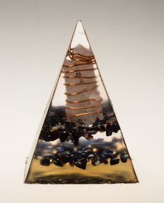 a triangle shaped glass sculpture sitting on top of a table