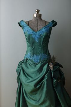 "This stunning handmade Victorian wedding gown was made for an Exhibit in the Springfield WVS art Museum where it was on display for 8 months in 2014. The corset features an emerald jewel toned taffeta hand appliqued with turquoise Indian lace, accented with swarovski crystals and swarovski rhinestones. It is boned with a combination of flat and spiral steel and has a strength layer of German coutil. The over skirt is made of the same taffeta accented with vintage rhinestone and stamped silver j Green Fitted Ball Gown For Debutante Ball, Green Corset Dress With Boned Bodice, Green Ball Gown Wedding Dress With Fitted Bodice, Green Wedding Evening Dress With Corset Back, Green Fitted Bodice Corset Dress For Wedding, Green Corset Dress With Fitted Bodice For Wedding, Fitted Taffeta Ball Gown For Wedding, Green Gown With Corset Back And Fitted Bodice, Fitted Bodice Taffeta Corset Dress For Wedding