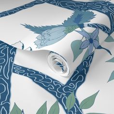 a blue and white floral wallpaper with green leaves on the bottom half of it