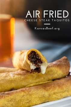 two pieces of bread with cheese and meat on them sitting on a plate next to a glass of beer