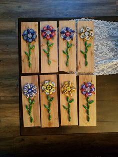 six wooden plaques with painted flowers on them