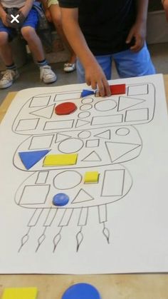 a group of people sitting around a table with a large piece of paper on it