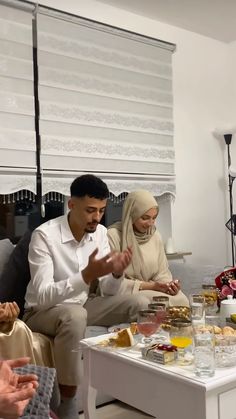 a group of people sitting around a table with food on it