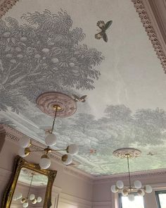 the ceiling is decorated with an elaborate mural and mirrors, along with two lamps on either side