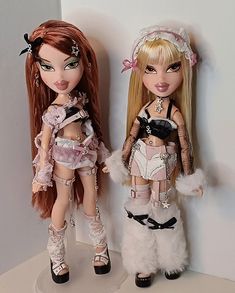 two dolls are standing next to each other