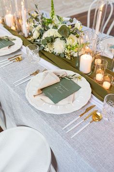 the table is set with candles, plates and napkins