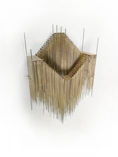 a sculpture made out of sticks on a white wall