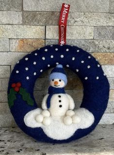 a snowman is sitting in the middle of a wreath