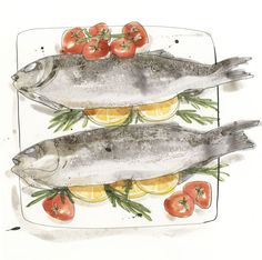 two fish on a plate with tomatoes and lemons