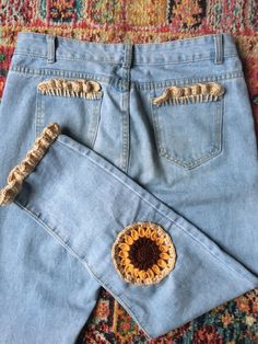 a pair of light blue jeans with crochet details on the back and sides