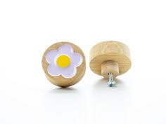 a pair of wooden knobs with a flower on the front and back of them