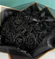 an open box with black roses in it