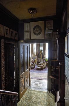 an open door leading to a living room with pictures on the wall and carpeted floor