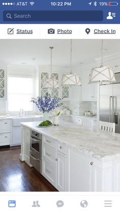 a large kitchen with white cabinets and marble counter tops, along with stainless steel appliances