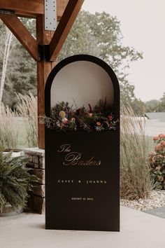 a sign with flowers on it that says the bride and groom