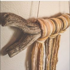 a piece of driftwood hanging on a wall next to some other wood and rope