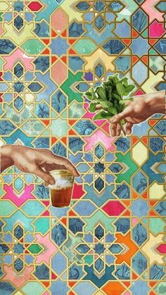 two hands reaching for something in front of a colorful mosaic wall with green leaves on it