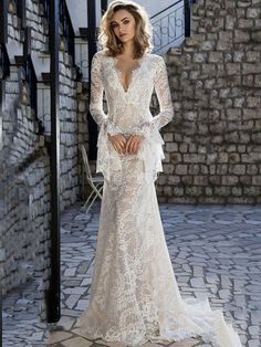 a woman in a white wedding dress standing next to stairs