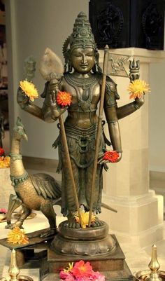 the statue is surrounded by flowers and other decorations