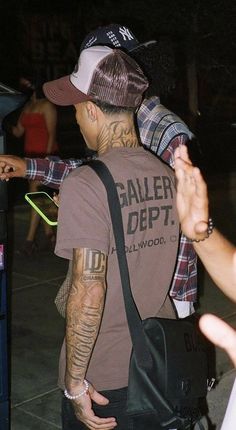 a man with tattoos on his arm is holding onto another man's shoulder as he walks through an airport