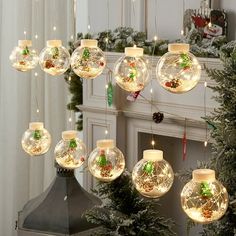 christmas decorations hanging from the ceiling in front of a fire place with lights on it