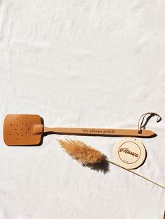 a wooden spatula with a feather on it