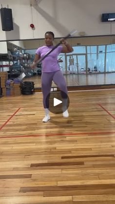 a woman standing on top of a hard wood floor holding a tennis racquet