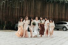 a group of bridesmaids are walking down the street