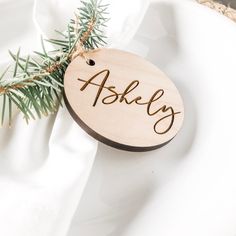 a wooden ornament with the word askley on it sitting on a white plate